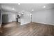 Open-concept living space with hardwood floors flowing into a modern kitchen with white cabinets and stainless appliances at 1865 S Knox Ct, Denver, CO 80219