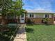Charming single-story home with a brick facade, well-maintained lawn and sidewalk leading to the front door at 11261 Clarkson St, Northglenn, CO 80233