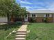 Charming single-story home with a brick facade, well-maintained lawn and sidewalk leading to the front door at 11261 Clarkson St, Northglenn, CO 80233