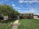 Charming single-story home with a brick facade, well-maintained lawn and sidewalk leading to the front door at 11261 Clarkson St, Northglenn, CO 80233