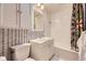 Updated bathroom features black and white patterned walls, and bathtub and shower combination at 2684 S Adams St, Denver, CO 80210