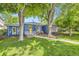 Inviting home exterior with vibrant blue siding, large trees, and a walkway leading to the cozy front porch at 2684 S Adams St, Denver, CO 80210