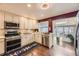 Bright kitchen featuring stainless steel appliances, white cabinetry, and a large window for natural light at 2684 S Adams St, Denver, CO 80210