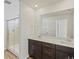 Bathroom featuring a double vanity with sleek, dark cabinets, white countertops and glass shower at 6504 N Malaya St, Aurora, CO 80019