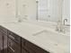 Close-up of a bathroom double vanity with a white countertop and contemporary chrome fixtures at 6504 N Malaya St, Aurora, CO 80019