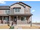 Beautiful two-story townhome showcasing a welcoming front porch and a combination of brick and siding at 6504 N Malaya St, Aurora, CO 80019