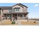 Well-maintained townhome featuring a covered front porch, complemented by brick and siding accents at 6504 N Malaya St, Aurora, CO 80019