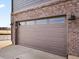 Exterior view of a brown two-car garage attached to a brick home at 6504 N Malaya St, Aurora, CO 80019