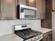 Close up of the kitchen features stainless steel appliances and stone countertops over dark cabinets at 6504 N Malaya St, Aurora, CO 80019