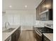 Kitchen with dark wood cabinets, stainless steel appliances and light stone countertops at 6504 N Malaya St, Aurora, CO 80019