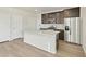 Modern kitchen features a large center island with stainless steel appliances and wood-look flooring at 6504 N Malaya St, Aurora, CO 80019