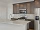 Close up of modern kitchen features stainless steel appliances, a center island and wood-look flooring at 6504 N Malaya St, Aurora, CO 80019