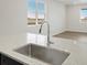 Kitchen featuring modern stainless steel sink and faucet plus a window with blinds at 6504 N Malaya St, Aurora, CO 80019