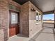 Charming brick-clad porch featuring a stylish front door and an outdoor lighting fixture, creating curb appeal at 6504 N Malaya St, Aurora, CO 80019