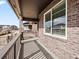 Inviting covered front porch with brick pillars and decorative railing, creating a cozy outdoor space at 6504 N Malaya St, Aurora, CO 80019