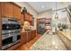 Gourmet kitchen with stainless steel appliances, wood cabinets and granite counters at 7717 S Grape Ct, Centennial, CO 80122