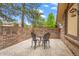 Private brick patio with outdoor seating, surrounded by lush landscaping and mature trees at 7717 S Grape Ct, Centennial, CO 80122