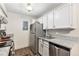 Compact kitchen with stainless steel appliances, granite countertops, and white cabinetry at 10150 E Virginia Ave # 13-204, Denver, CO 80247