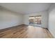Minimalist living room showcasing bright wood floors, white walls, and sliding glass doors leading to outdoor space at 1028 Coronado Pkwy # C, Denver, CO 80229