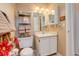 Well-lit bathroom with a white vanity, toilet, and decorative shelving at 4931 Garrison St # 204G, Wheat Ridge, CO 80033