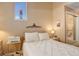 Cozy bedroom with a comfortable bed, and a glimpse into an en-suite bathroom at 4931 Garrison St # 204G, Wheat Ridge, CO 80033
