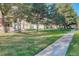 Well-maintained front yard with a sidewalk and mature trees, offering a welcoming approach to the home at 4931 Garrison St # 204G, Wheat Ridge, CO 80033