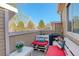 Relaxing outdoor patio with cozy seating and views of mature trees at 4931 Garrison St # 204G, Wheat Ridge, CO 80033