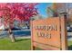 Garrison Lakes Covenant Controlled Community sign with a vibrant pink tree and parked cars in the background at 4931 Garrison St # 204G, Wheat Ridge, CO 80033