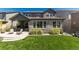 Charming backyard featuring a covered patio, stone accents, and well-manicured lawn, ideal for entertaining at 6643 Barnstead Dr, Castle Pines, CO 80108