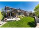 Spacious backyard showcases a covered patio, lush lawn, and privacy landscaping for outdoor relaxation at 6643 Barnstead Dr, Castle Pines, CO 80108