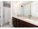 Bathroom with double vanity sinks, dark wood cabinets, and a shower-tub combination at 6643 Barnstead Dr, Castle Pines, CO 80108