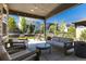 Cozy covered patio features stylish outdoor seating, string lights, and a view of the landscaped backyard at 6643 Barnstead Dr, Castle Pines, CO 80108
