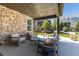 Stylish covered patio with stone accents, outdoor seating, and a modern fire pit for cozy gatherings at 6643 Barnstead Dr, Castle Pines, CO 80108