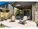 Relaxing covered patio with comfortable seating, stone accents, and a grill for outdoor entertaining at 6643 Barnstead Dr, Castle Pines, CO 80108