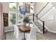 Bright dining room with large windows, modern light fixture, and staircase view at 6643 Barnstead Dr, Castle Pines, CO 80108