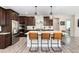 Modern kitchen boasts a center island with seating, stainless steel appliances, and dark wood cabinets at 6643 Barnstead Dr, Castle Pines, CO 80108