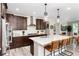 Modern kitchen boasts stainless steel appliances, dark cabinets, large island with quartz countertops, and pendant lighting at 6643 Barnstead Dr, Castle Pines, CO 80108