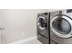 Laundry room with stainless steel, front loading washer and dryer machines at 6643 Barnstead Dr, Castle Pines, CO 80108