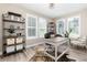 Well-lit home office with a neutral color scheme, modern desk, and plantation shutters at 6643 Barnstead Dr, Castle Pines, CO 80108