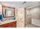 Well-lit bathroom with a walk-in shower, vanity, and neutral tile flooring at 16929 W 63Rd Ln, Golden, CO 80403