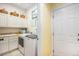 Functional laundry room with modern washer and dryer, white cabinetry, and utility sink at 16929 W 63Rd Ln, Golden, CO 80403
