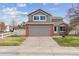 Two-story house with gray siding, brick accents, and a two-car garage at 6370 Wolff St, Arvada, CO 80003