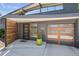 Modern front entrance with wood and glass garage door, and a green planter at 658 Poplar St, Denver, CO 80220