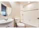 Bright bathroom features a round mirror, a white sink, toilet and tiled tub and shower at 20431 E Union Cir, Aurora, CO 80015