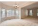 Open dining room area with a chandelier, carpeted floor, and lots of natural light from large windows at 20431 E Union Cir, Aurora, CO 80015
