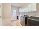 This laundry room features a stainless washer and dryer set, a sink, and overhead cabinets at 20431 E Union Cir, Aurora, CO 80015