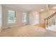 Bright living room featuring large windows, fresh carpet, and staircase leading to the upper level at 20431 E Union Cir, Aurora, CO 80015