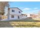 View of a spacious, grassy backyard with a white two-story house and sunny blue sky above at 3733 W 97Th Ave, Westminster, CO 80031