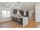 Stylish eat-in kitchen island with waterfall countertop, barstool seating, and modern pendant lighting at 3733 W 97Th Ave, Westminster, CO 80031