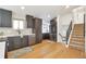 Modern kitchen featuring sleek appliances, dark cabinets, and an adjacent staircase for easy access at 3733 W 97Th Ave, Westminster, CO 80031